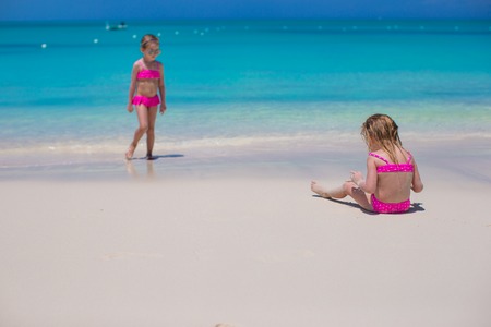 Little girls walking along the white beach and having funの写真素材