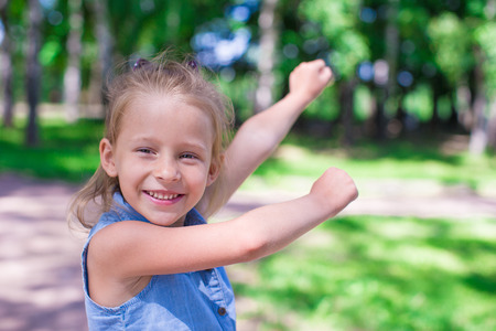 Happy adorable girl enjoy summer day play in the parkの写真素材