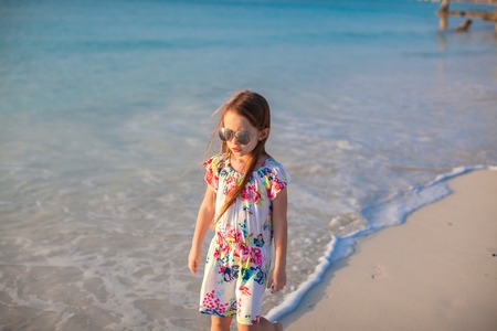 Adorable little girl walking at white tropical beachの写真素材