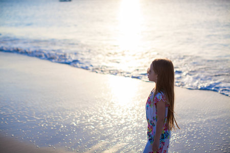 Adorable little girl walking at white tropical beachの写真素材