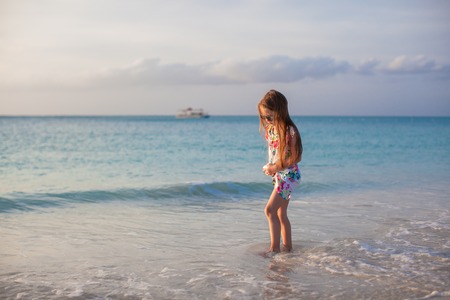 Adorable little girl walking at white tropical beachの写真素材