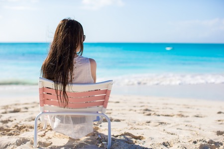 Young beautiful woman on beach during her summer vacation