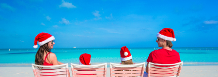 Happy family in Christmas Hats having fun on exotic beachの写真素材