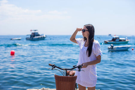 Pretty woman on bicycle in summmer vacationの写真素材