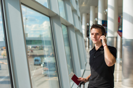 Businessman talking on smartphone walking inside in airportの写真素材