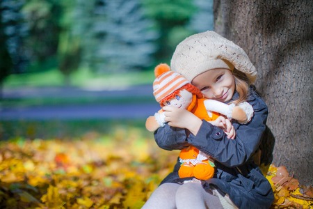 Cute little girl at warm sunny autumn day outdoorの写真素材