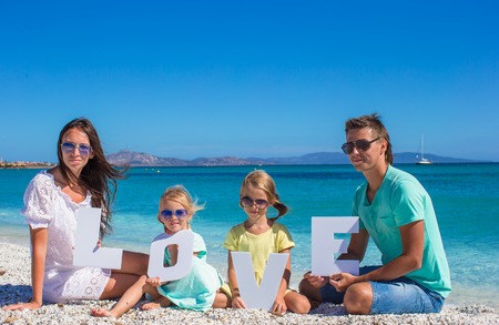 Young beautiful family with two kids on tropical vacationの写真素材