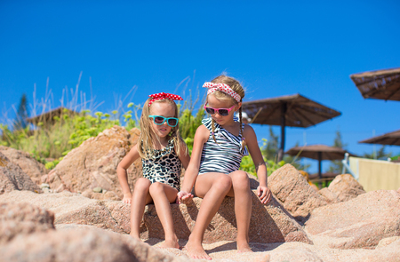 Adorable cute girls have fun on white beach during vacationの写真素材
