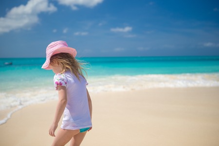 Adorable little girl playing in shallow water at perfect beachの写真素材