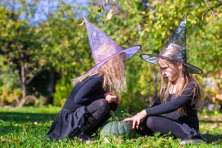 Little girls casting a spell on Halloween in witch costumeの写真素材
