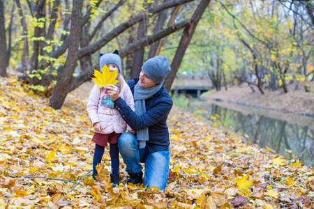 Little girl and dad in autumn park outdoorsの写真素材