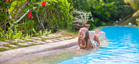 Little adorable girl in swimming pool relax outdoorsの写真素材