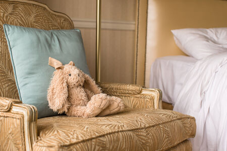 Soft plush toy bunny on a chair in a hotel roomの写真素材
