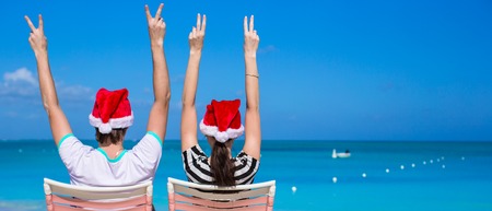 Young romantic couple in Santa hats during beach vacation