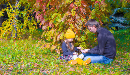 Father with cute daughter in autumn park outdoorsの写真素材