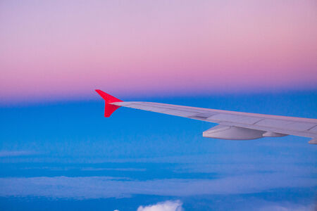 Wing of an airplane flying above the clouds