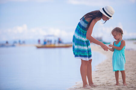 Little girl and young mother on tropical beachの写真素材