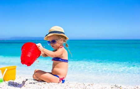 Adorable little girl playing with toy on beach vacationの写真素材