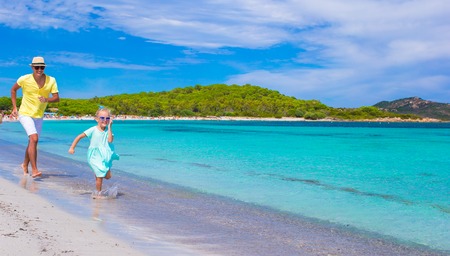 Young father and little daughter have fun during tropical beach vacation
