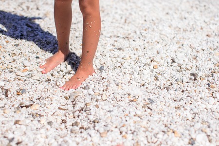 Closeup of little girl feet on tropical sandy beachの写真素材