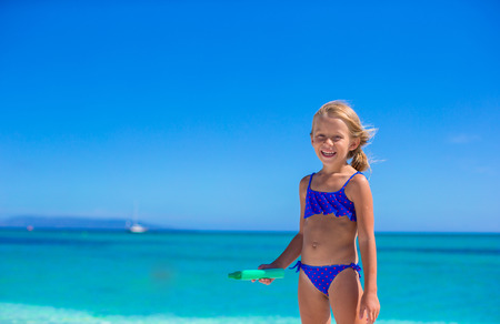 Adorable little girl have fun at tropical beachの写真素材