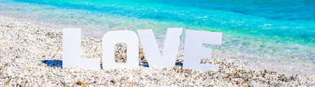 Word love on tropical beach background of turquoise sea and blue skyの写真素材
