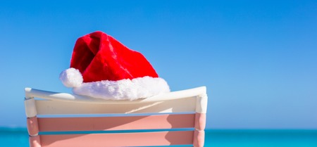 Closeup red Santa hat on chair longue at tropical beachの写真素材