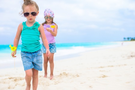 Little adorable girls on white tropical beachの写真素材
