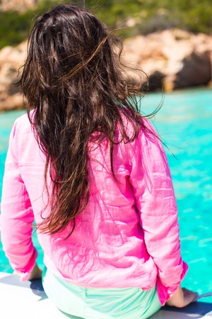 Beautiful young girl relaxing on the boat in open seaの写真素材