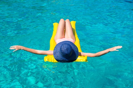 Woman relaxing on inflatable mattress in clear seaの写真素材