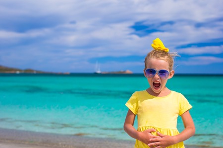 Adorable little girl have fun at tropical beach during vacationの写真素材