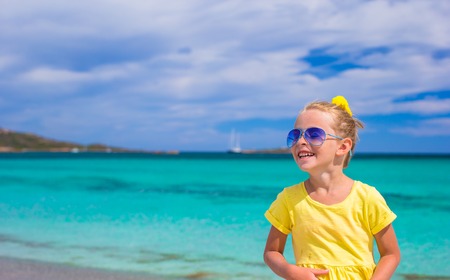 Adorable little girl have fun at tropical beach during vacationの写真素材