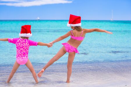 Little girls in Santa hats during summer vacationの写真素材