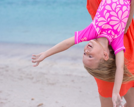 Little happy girl enjoy summer vacation with her mom at exotic beachの写真素材