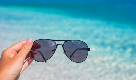 Close up of sunglasses on tropical beachの写真素材