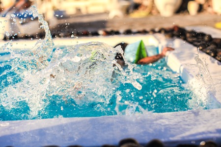 Little girl splashes in swimming poolの写真素材