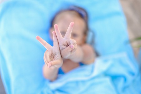 Little girl showing thumbs up outdoorの写真素材
