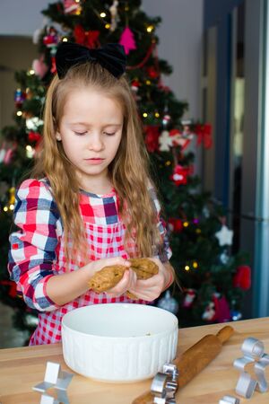 Little girl baking gingerbread cookies for Christmas at home kitchenの写真素材