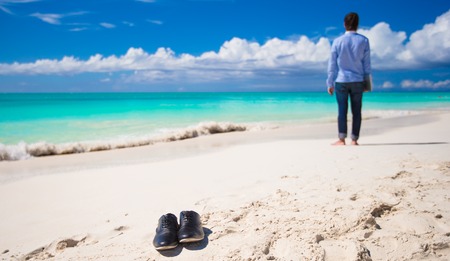Young man with laptop during tropical beach vacationの写真素材