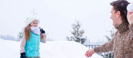 Happy father and little girl playing snowballs in winter snowy dayの写真素材