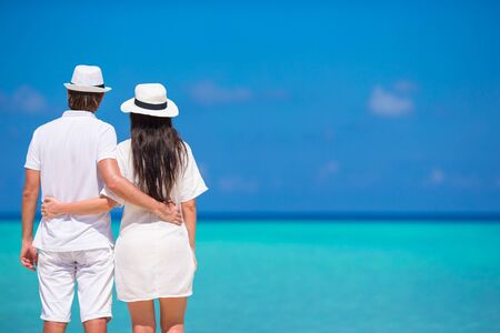 Back view of young couple on white beach at summer vacationの写真素材