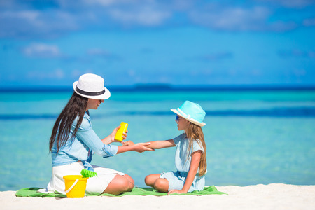 Young mother applying sunscreen on her kid