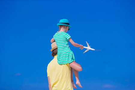 Young man and little girl with miniature of airplane at beachの写真素材