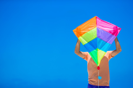 Young man with a kite on a background of turquoise seaの写真素材