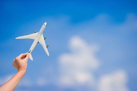 Small white miniature of an airplane on background of blue skyの写真素材
