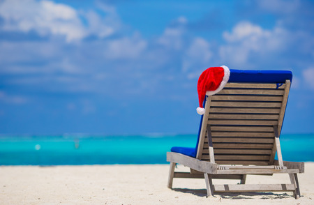 Red santa hat on chair longue at tropical white beachの写真素材