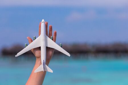Little white toy airplane on background of turquoise sea