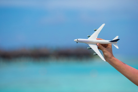 Little white toy airplane on background of turquoise sea