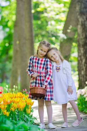 Little adorable girls walking in the lush garden of tulipsの写真素材