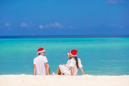 Happy family of three in Santa Hats on beachの写真素材